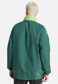 Grüne, wasserdichte Jacke mit einem kontrastierenden hellgrünen Kragen. Sie hat eine lockere Passform, elastische Bündchen und strukturierte Details an den Ärmeln.