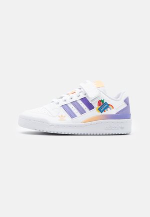 Baskets blanches Adidas avec des bandes violettes, une bride à velcro, des accents orange et un patch coloré brodé d'une fraise et d'un arc-en-ciel sur le côté.