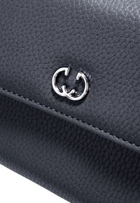 Graue, strukturiertes Lederhandtasche mit einem silbernen, ineinander verschlungenen Doppel-G-Logo. Verfügt über weiße Nähte entlang des Randes für einen Kontrast.