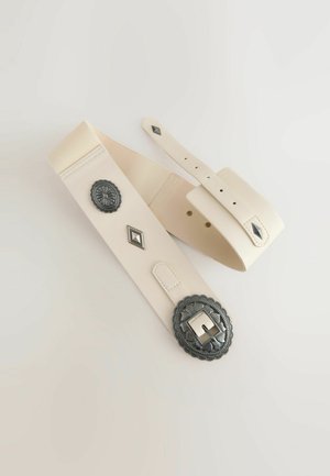 Cintura color crema con una finitura testurizzata, dotata di una grande fibbia metallica ornamentale e accenti metallici decorativi.