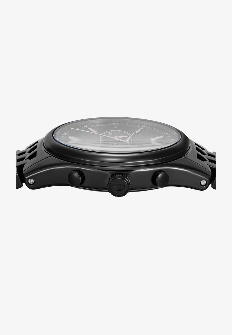 Schwarze analoge Uhr mit rundem Zifferblatt, strukturiertem Gehäuse, zwei Tasten und einer Krone, ausgestattet mit einer klaren Glasabdeckung und kontrastierenden pinkfarbenen Stundenmarkierungen.