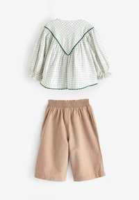 Bomullsoutfit med en grövrutigt blus som har en scallopkrage och randiga beige shorts med elastiskt midjeband och sidofickor.