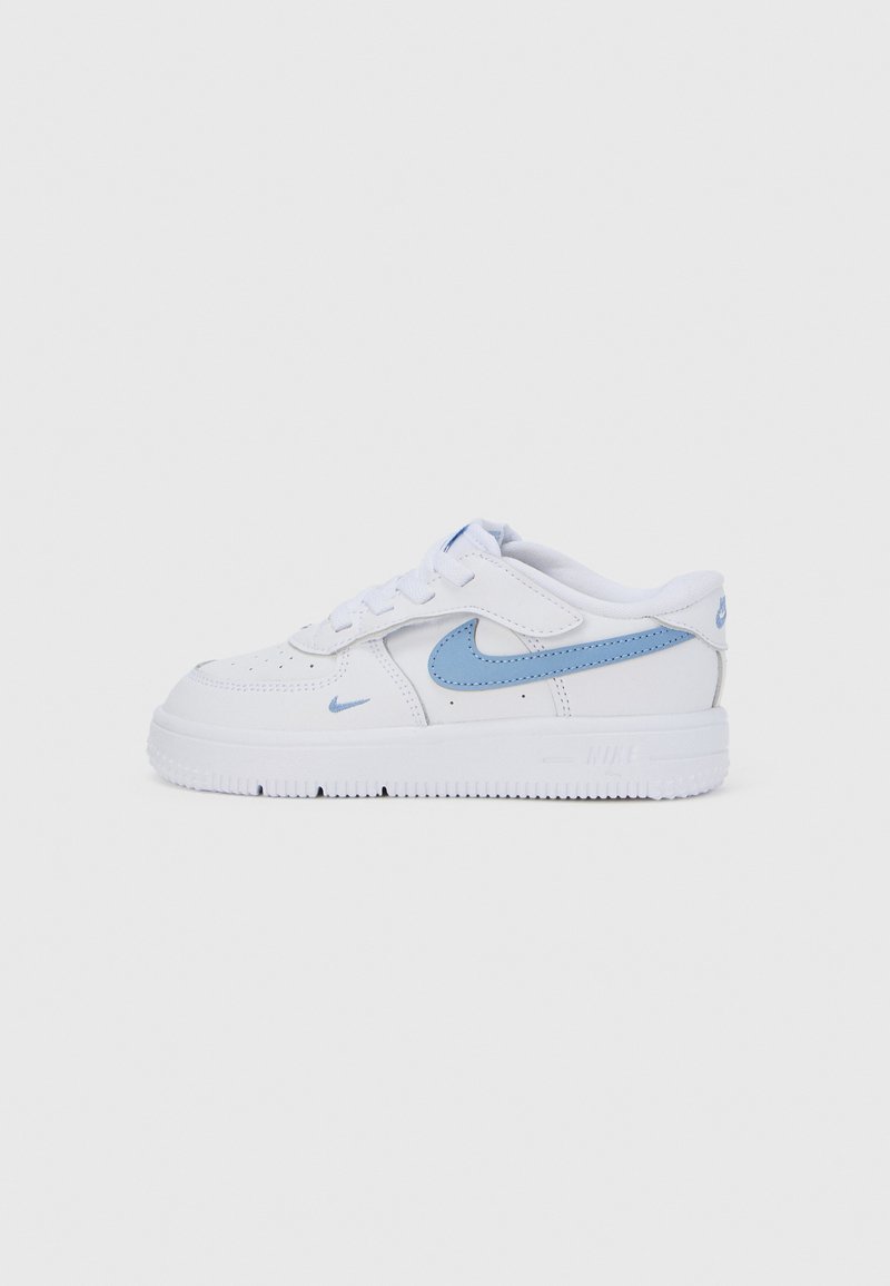 Zapatillas blancas de Nike con un swoosh azul, puntera perforada para la transpirabilidad y una suela de goma texturizada para mayor tracción.