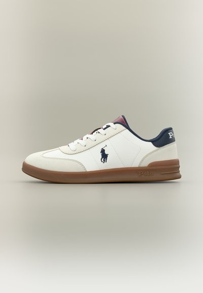 Λευκό sneaker χαμηλού τύπου με καφέ σόλα, ναυτικό γιακά και λογότυπο Polo στο πλάι και στη φτέρνα, εμφανίζεται σε ουδέτερο φόντο.