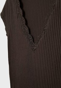 Približna slika temno rjavega rebrastega brezrokavnika z valovito čipkasto obrobo ob globokem V-izrezu.