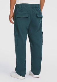 Mørke teal cargo bukser med elastisk talje, to store baglommer og sidelommer. Glat stof med en afslappet pasform.