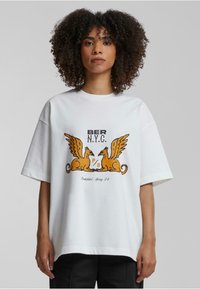 Hvit bomulls t-skjorte med korte ermer, med et lekent grafisk design av to gyldne vingede skapninger og tekst i svart og oransje.