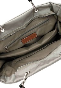 Beige Stoffhandtasche mit zwei Fächern, einer Reißverschlusstasche und einem braunen Lederetikett im Inneren. Silberelemente überall.