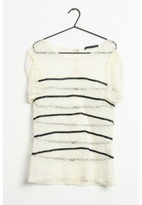 Haut en dentelle crème avec des rayures noires horizontales. Présente des manches courtes et une fermeture à bouton à l'arrière. Tissu doux et texturé.