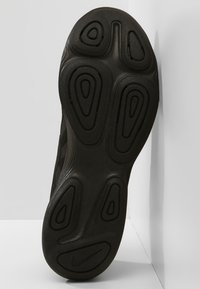 Mustan urheilukengän pohja, joka sisältää teksturoitua kumia monimuotoisilla kuvioilla pidon parantamiseksi, ja jota leimaa tyylikäs, pyöristetty muotoilu.