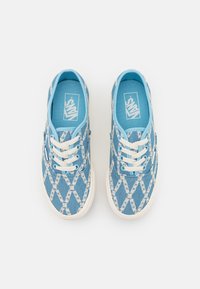Blue canvas sneakers featuring a diamond pattern in white. White rubber sole, blue laces, and an inner lining logo.