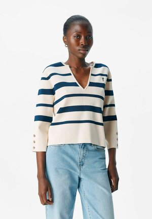 Gestreifter Strickpullover in Marineblau und Creme, mit V-Ausschnitt, 3/4-Ärmeln und Knopfakzenten an den Ärmelbündchen.