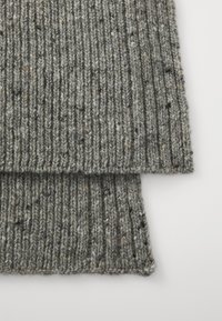 Tjock, räfflad stickad halsduk i grå nyanser med inslag av brunt och svart, som visar en texturerad yta och en lång rektangulär form.