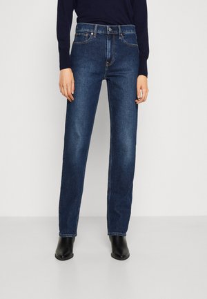 Dark blue denim jeans with a straight leg design, five pockets, and subtle orange stitching. Worn with black ankle boots.