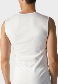 Biała koszulka bez rękawów wykonana z bawełny, z okrągłym dekoltem i gładką teksturą, o dopasowanym kroju widocznym od tyłu.