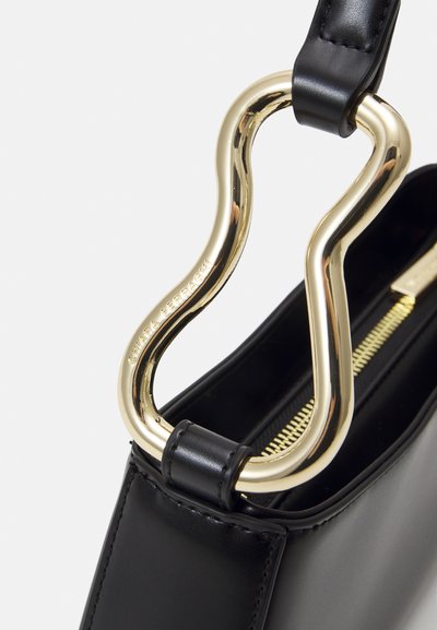 Borsa a tracolla in pelle nera con una maniglia curva dorata. Presenta una chiusura con zip e una texture liscia. Design minimalista senza pattern visibili.