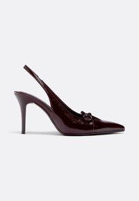 Escarpin à talon haut slingback en cuir verni bordeaux foncé avec bout pointu et petit nœud décoratif sur le dessus, vu de profil latéral.