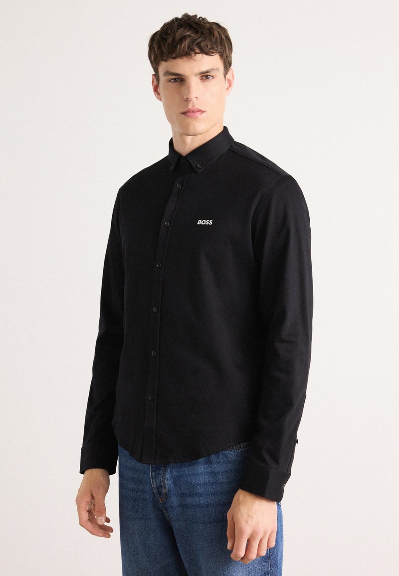 Black button-up shirt made of cotton with a collar, featuring an embroidered white "BOSS" logo on the chest and a smooth texture.