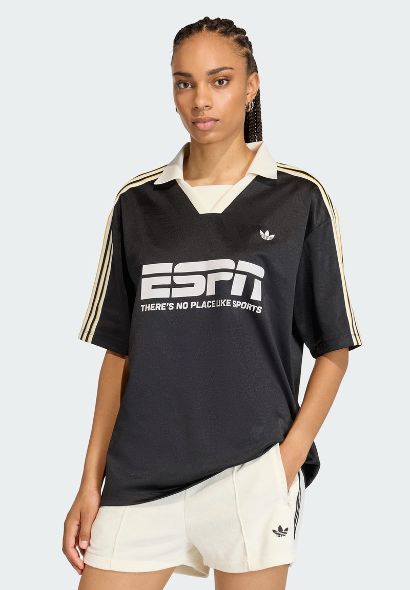 Μαύρη αθλητική φανέλα με λευκό λογότυπο "ESPN", χρυσές ρίγες στα μανίκια και κρεμ γιακά. Συνδυάζ εται με κρεμ σορτς με λογότυπο.