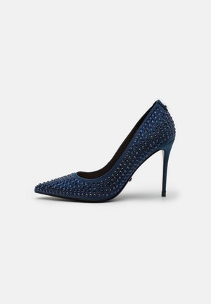 Marineblå højhælet stiletto-pumpe med spids tå og dekoreret med små mørke og blå runde nitter.