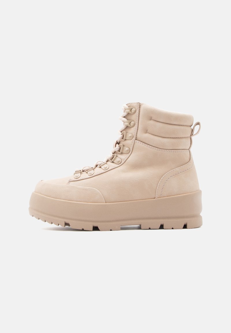 Beige lace-up potītes, izgatavotas no gludas ādas, ar mīkstinātu apkakli, platu zoli un diskrētu aparatūru. Rakstaina virsma.