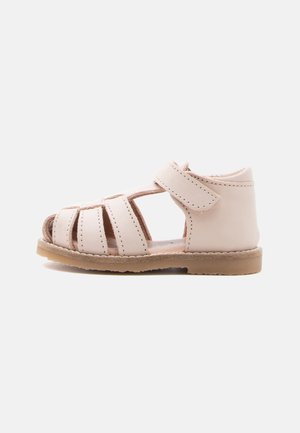 Sandale rose clair pour tout-petit avec talon fermé, brides ouvertes à l'avant et une seule bride à la cheville avec velcro, posée sur un fond gris clair.