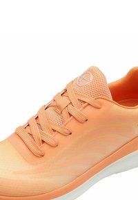 Chaussure de course orange clair avec tige en mesh, lacets assortis, motif ondulé subtil et semelle blanche, vue en perspective de dessus sur le côté.