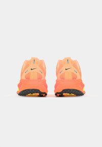 Nike löparskor i stark orange med meshöverkant, distinkt hälflik och svart yttersula med mönstrade spår och färgglada detaljer.