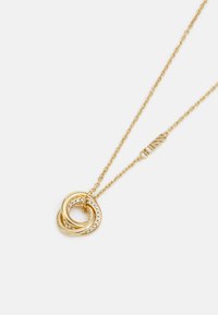 Gouden ketting met twee in elkaar grijpende ringen; de ene versierd met heldere kristallen. Voorzien van een fijne ketting en een logo-tag.