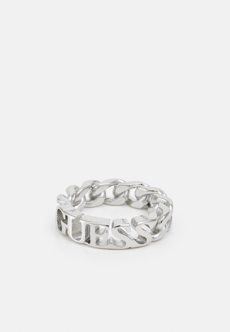 Silver chain ring featuring cut-out "GUESS" lettering, textured surface, and rounded links, creating a bold geometric design.