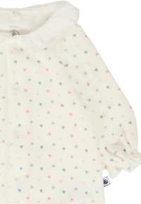 Indumento per neonati bianco con colletto arricciato e bottoni. Presenta vivaci motivi a cuori in rosa, viola e blu su tutta la stoffa.