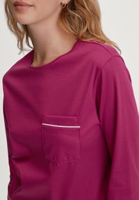 Magenta langemouwen shirt van zachte stof, met een ronde hals, een borstzak met witte rand en een losse pasvorm.