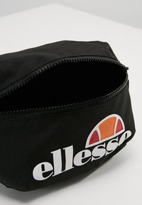 Black fabric pouch with a zip closure, featuring a colorful logo print in white, orange, and red. Interior is lined and empty.