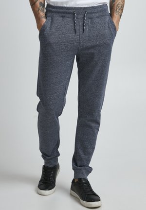 Gray sweatpants made of soft jersey material, featuring an elastic waistband with drawstring, side pockets, and tapered ankles.