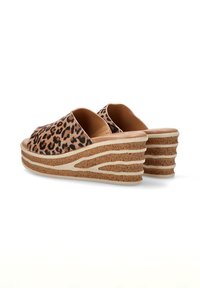 Sandalias de cuña con estampado de leopardo y plataforma de corcho, que cuentan con un interior suave en tono marrón y un diseño de suela en forma de ondas superpuestas.