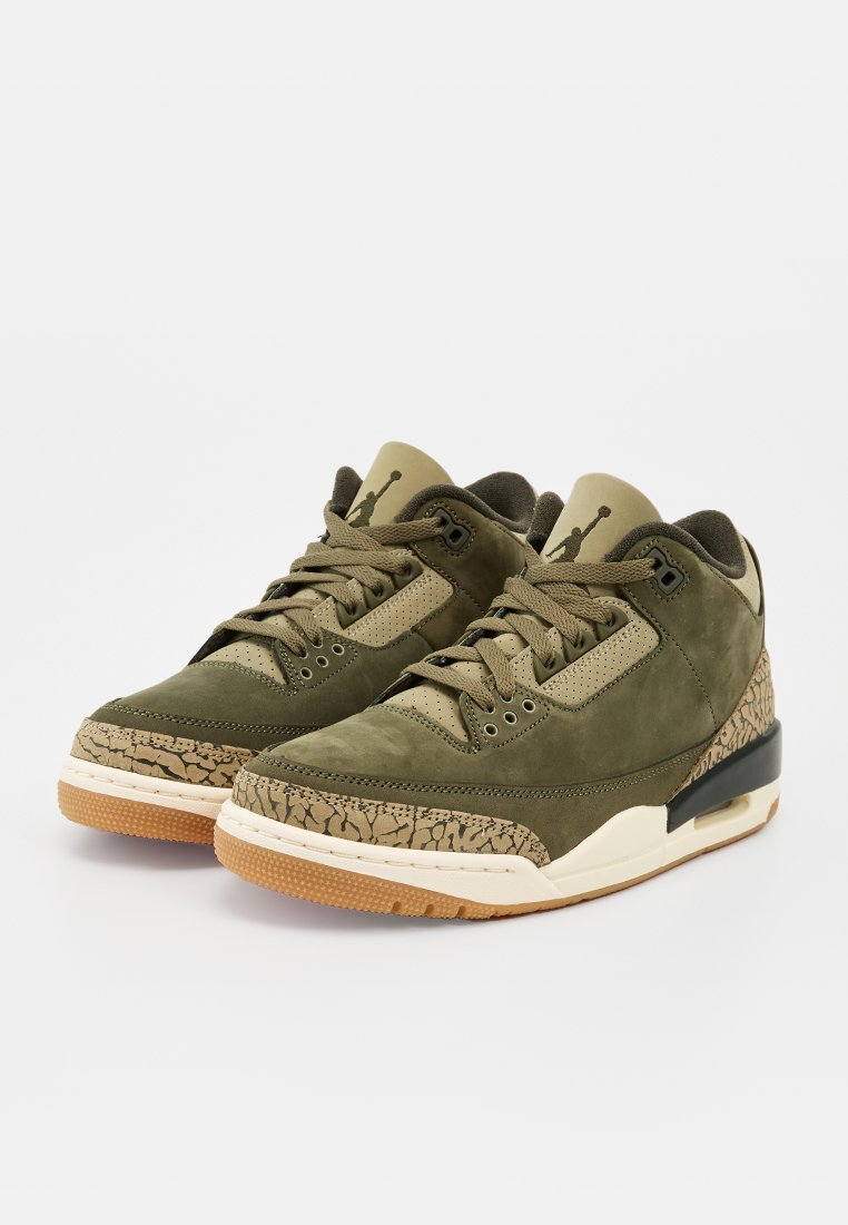 Paire de baskets Air Jordan vert olive et beige avec motifs texturés et semelles en caoutchouc sur fond blanc.