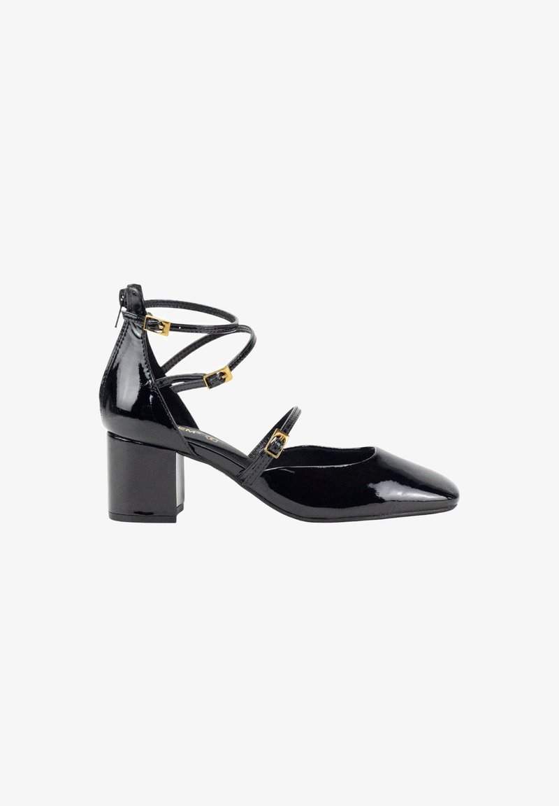 Zapatos de charol negro con tacones de bloque y punta afilada, que cuentan con correas en el tobillo y hebillas en tono dorado. Textura suave y diseño minimalista.