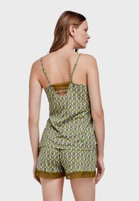 Set di pigiama verde con motivo, composto da un top senza maniche con rifiniture in pizzo e pantaloni corti abbinati con bordi scallop, che presenta motivi floreali.