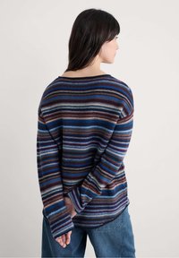 Pulover tricotat cu dungi multicolore, având dungi albastre, burgundii și crem, cu umeri lăsați și o croială lejeră. Textură moale, mâneci lungi.