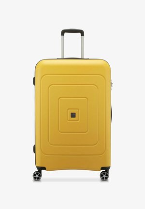 Valigia rigida gialla con un design testurizzato a cerchi concentrici, maniglia retrattile e quattro ruote per la mobilità. Presenta un piccolo logo.