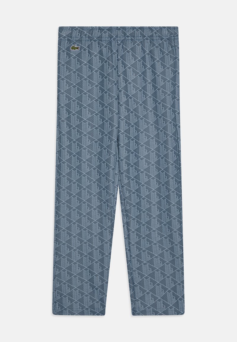 Blauwe trainingsbroek met een elastische tailleband. De stof heeft een geometrisch patroon met een klein groen logo aan de linkerkant.