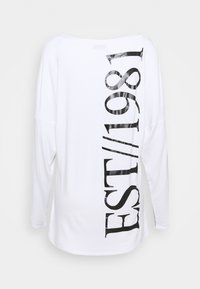 Weißes Langarmshirt mit großem schwarzem vertikalem Aufdruck "1981 / EST" auf dem Rücken.