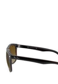 Occhiali da sole in plastica nera con lenti marroni, caratterizzati da una montatura quadrata. Logo Ray-Ban sulle tempie, made in Italy.