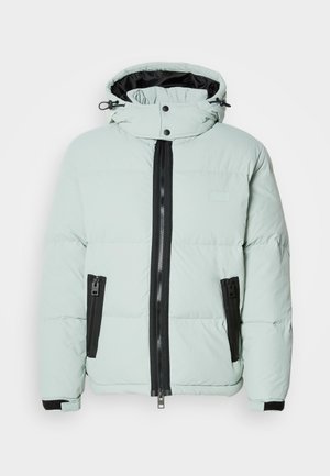 Padded jacket v svetlo mätovej zelenej farbe s vysokým golierom, čiernym zipsom a dvoma bočnými vreckami. Obsahuje elastické manžety a minimálne označenie značky.