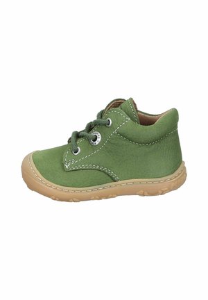 Grüner Wildlederschuh für Kleinkinder mit beige-gummierter Sohle, weißen Nähten und grünen Schnürsenkeln vor weißem Hintergrund.