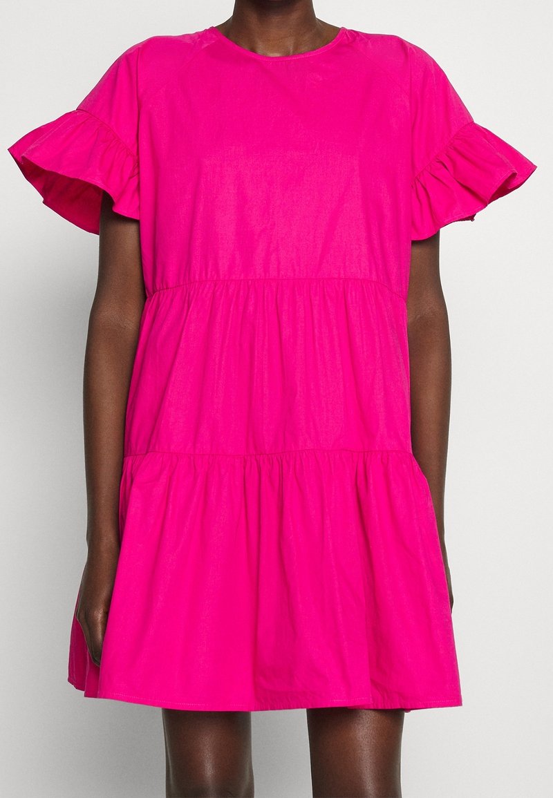Vestido de algodón rosa con mangas cortas con volantes, diseño en línea A con capas, cuello redondo y textura suave. Incluye bolsillos laterales.