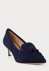 Ναυτικό σουέτ παπούτσι με μυτερή μύτη, διαθέτοντας διακοσμητικό φουντωτό τασέλ και μεσαίου ύψους τακούνι. Μαλακή εσωτερική επένδυση για άνεση.