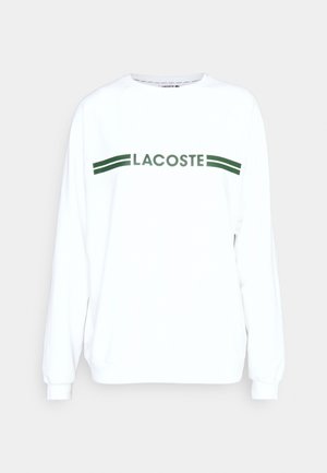 Witte sweatshirt met lange mouwen en groene "LACOSTE" tekst en strepen over de borst. Gemaakt van zachte, lichte stof. Losse pasvorm.