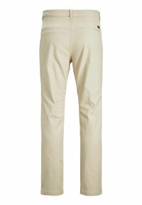 Beige Baumwollhosen mit geradem Bein, ausgestattet mit zwei Gesäßtaschen und minimalem Zubehör. Glatte Textur und einfache Verarbeitung.