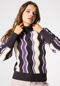 Suéter de punto con un cuello alto acanalado, rayas onduladas en crema, púrpura y negro, con puños y dobladillo acanalados. Tela texturizada.